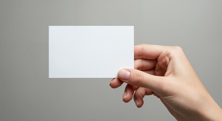 Blank Business Card: A poised hand delicately presents a clean, blank business card against a soft background, ready for personalized branding, conveying professionalism and versatile marketing.