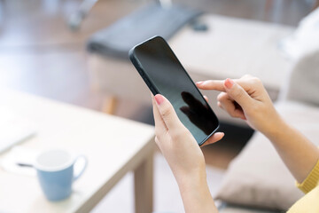 Close-up shot of a person's hands holding and interacting with a black modern smartphone screen