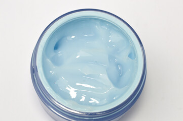 Close-up top view of light blue hydrating gel or cream in a cosmetic jar. Perfect for skincare, moisturizing, beauty, dermatology, cooling effect, and cosmetic product mockup.