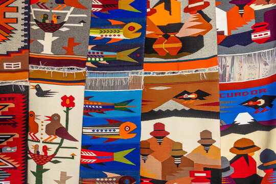 Colorful traditional wool rugs and blankets with Andean designs are sold at the Plaza de los Ponchos artisan market in Otavalo, Imbabura Province, Ecuador	