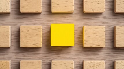 A single yellow block stands out among multiple wooden blocks, emphasizing contrast and uniqueness in a minimalist design.