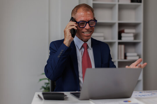 Happy smiling laughing American positive ethnic man business employer entrepreneur smile pleasant conversation smartphone call talk mobile phone businessman guy male in office typing laptop
- Powered by Adobe