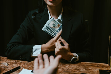 Woman in suit hiding bribe money in pocket, engaging in a corrupt business deal at a table with another person