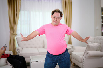 A man with down syndrome is dancing in the living room