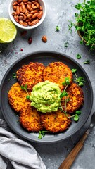Savory, golden fritters topped with avocado spread, garnished with greens