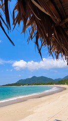 Tropical beach with golden sand, turquoise sea, and green mountains under a bright blue sky. A...