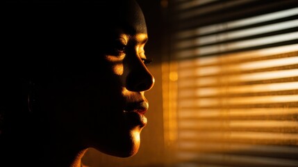 Woman's Profile in Golden Light Through Blinds