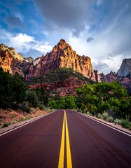 Scenic road winding through red rock mountains under a dramatic sky