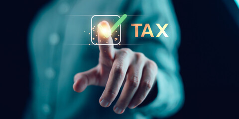 Close-up of a hand pressing a digital check mark beside the word TAX. Concept of online tax approval, digital finance, e-filing, and smart financial technology for modern business management.