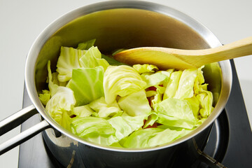 キャベツを鍋で炒める
