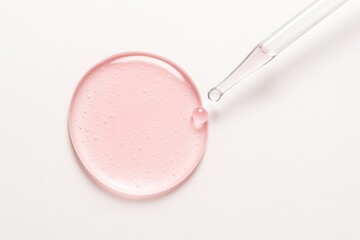 Pink transparent serum smear as a circular pool with a droplet about to land