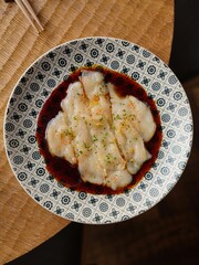 Elegant white fish carpaccio drizzled with flavorful sauce. This culinary delight is perfect for showcasing fine dining or inspiring gourmet food creations.