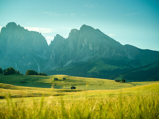 Beautiful sunrise with fields, cottages and mountains. Alpe di Siusi, Dolomites, Italy