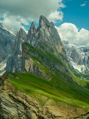 Spectacular view of Seceda ridgeline in the Dolomites, Italy. Dramatic limestone peaks rising above vibrant green slopes under a bright summer sky &mdash; a breathtaking natural masterpiece.