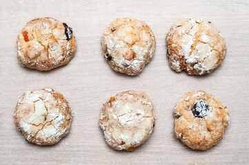 Delicious homemade amaretti cookies with dried fruit on a light wooden surface