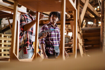 African American carpenters inspecting wood and reviewing documents.