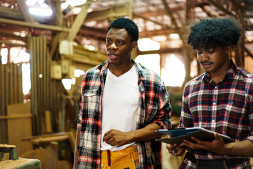African American carpenters inspecting wood and reviewing documents.
