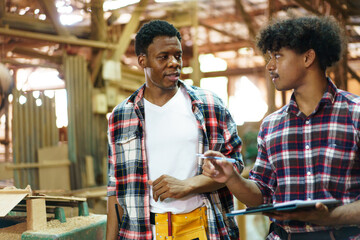 African American carpenters inspecting wood and reviewing documents.