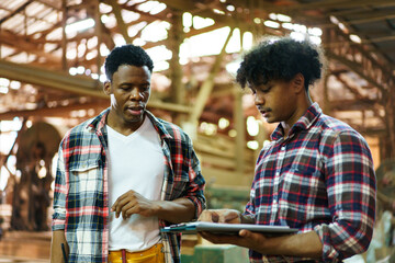 African American carpenters inspecting wood and reviewing documents.