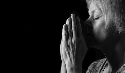 woman praying with hands together on grey black background with people stock image stock photo