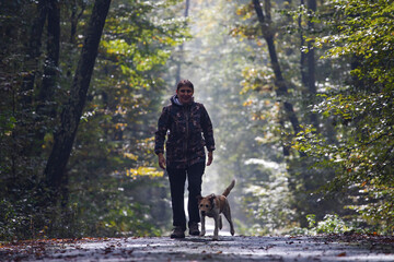 Woman and her dog in autumn landscape