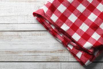 Obraz premium Red checkered tablecloth on white wooden table background, top view, copy space.