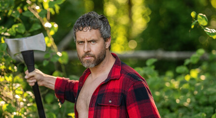 Lumberjack tired with heavy axe. Strong man work in forest. Man in forest with axe. Lumberjack carries axe. Deforestation. Mature sweating man with axe. Lumberjack in woods with ax, banner