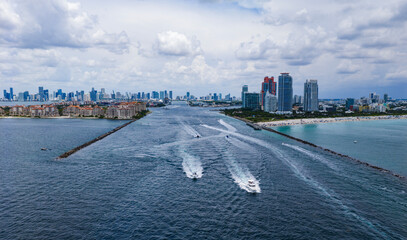 Luxury yacht cruising near Miami skyline. Aerial view of boats on turquoise waters in Miami. Yacht...