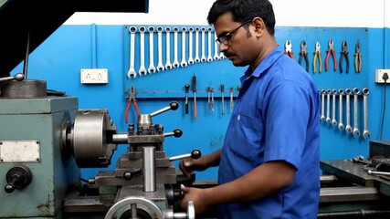 Man operating lathe in workshop turning metal. A focused shot of skillful work. Precision engineering, industrial technology, manufacturing process.