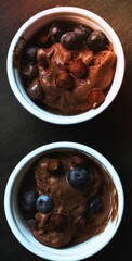 Two bowls of dark food with a rich texture and deep color