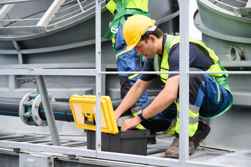 An industrial technician opening toolbox in the factory, The technician is dressed in protective gear, indicating a focus on safety and professionalism