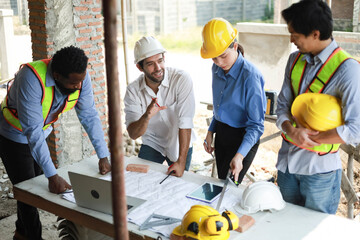 A group of engineers and staff met to discuss and work together to assess the progress of the residential construction site.