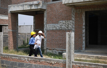 Architects and engineers work together to assess the progress of construction of houses in the village, building houses to standards that are strong and correct according to the design.