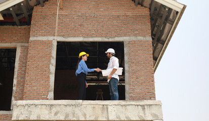 Architects and engineers work together to assess the progress of construction of houses in the...