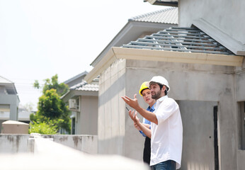 Female engineers and architects stand in front of a construction site, discussing their work, and...