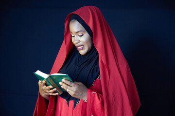 Muslim woman reading Quran on black background