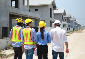 A group of civil engineers discussed and inspected the construction of houses according to...