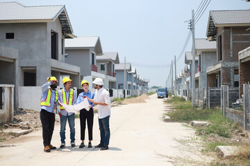 A group of civil engineers discussed and inspected the construction of houses according to...
