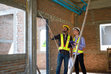 Male and female engineers discuss, inspect, and construct houses in the village. They are...