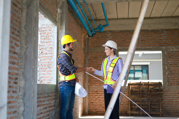 Male and female engineers discuss, inspect, and construct houses in the village. They are...
