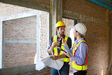 Male and female engineers discuss, inspect, and construct houses in the village. They are...
