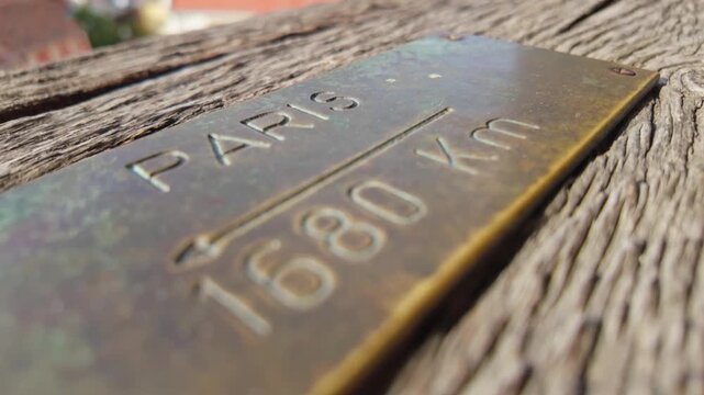 Close-up of a metal plate indicating the distance to Paris, France from the Clock Tower in Sighișoara, Romania.