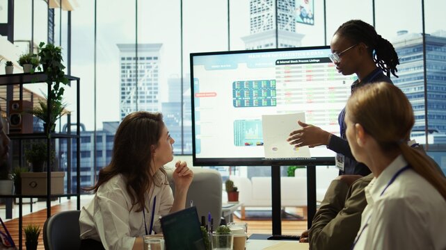 Employees team analyzing infographics to offer solutions for new project, looking to finish tasks before deadline. Enterprise coworkers attending problem solving conference in boardroom. Camera B.