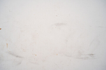 A textured white surface with faint scratches and marks.