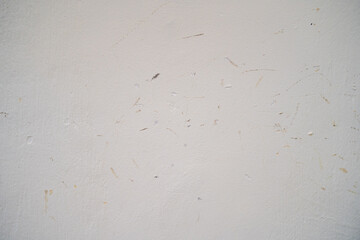 Textured white wall with faint marks and scratches.
