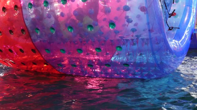 inflatable water roller, also known water zorb or water walking ball in a body of water. 