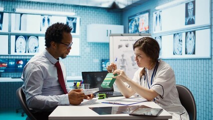 Woman specialist prescribing antibiotics and vitamins on medical receipt, recommending dosage for remedy and giving professional instructions. Medic offering advice for patient. Camera B.