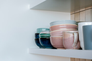 Dishes on the shelf, a stack of clean plates and bowls.