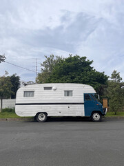 blue and white vintage camper van parked on the road
