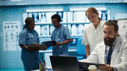 Healthcare professionals examine human anatomy scans to develop treatment plans, teamwork and...